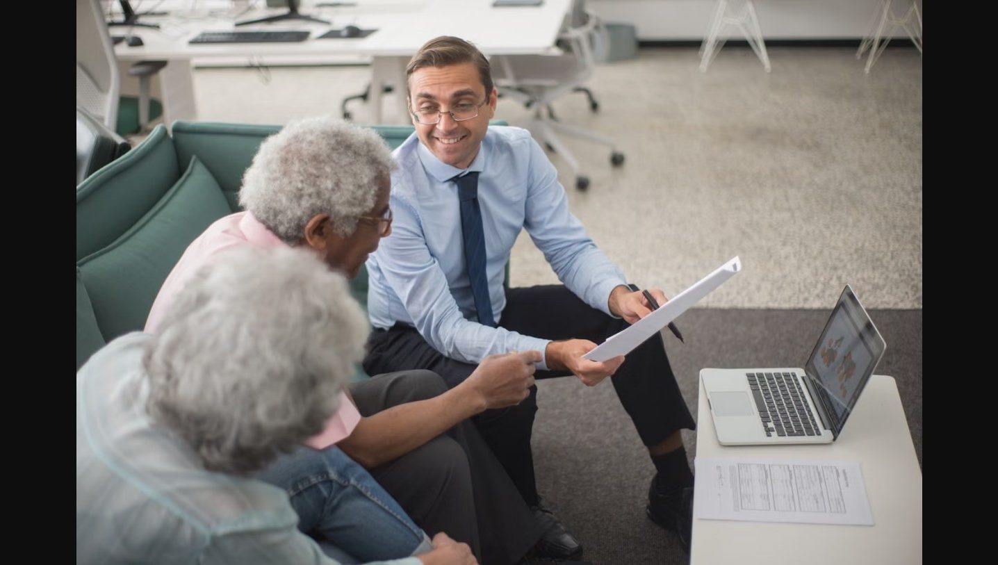 An advisor reviewing paperwork with an older couple